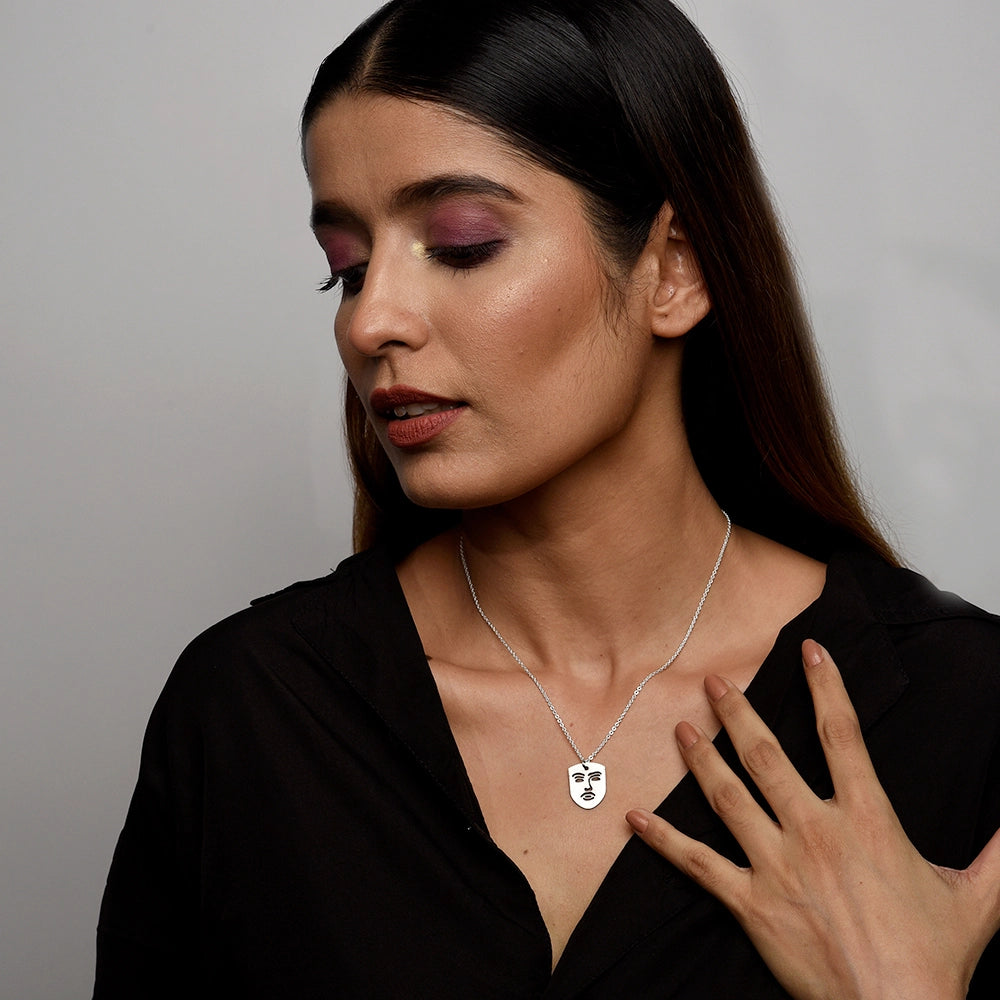The Face Necklace with modern face-shaped pendant on a sleek chain