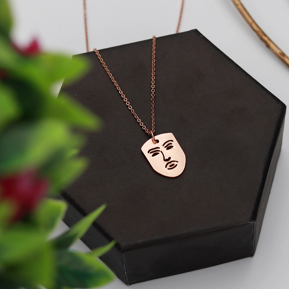The Face Necklace with modern face-shaped pendant on a sleek chain